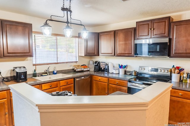 9930 Amber Breeze, San Antonio, TX 78245 - kitchen with stainless steel appliances, a sink, decorative light fixtures, and a center island