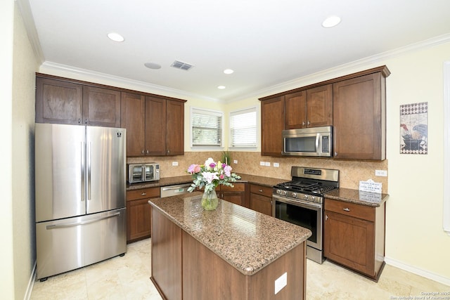 414 Aspen, San Antonio, TX 78253 - kitchen with stainless steel appliances, dark stone countertops, a kitchen island, crown molding, and backsplash