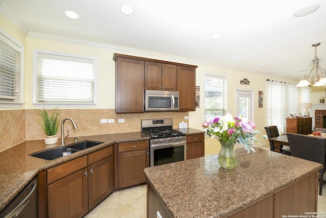 414 Aspen, San Antonio, TX 78253 - kitchen featuring appliances with stainless steel finishes, a sink, dark stone counters, ornamental molding, and a center island