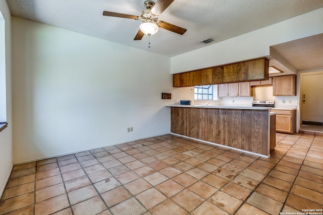 15314 Artesian Oaks, San Antonio, TX 78232 - kitchen featuring a textured ceiling, a peninsula, ceiling fan, and light countertops