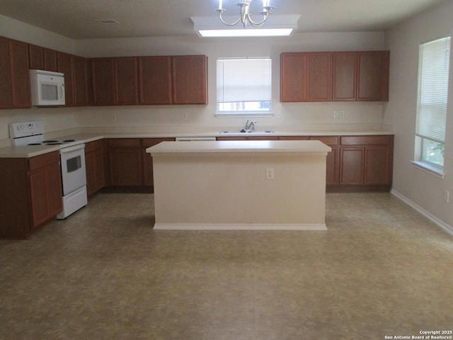 11011 Crystal Pln, Live Oak, TX 78233 - kitchen featuring white appliances, a sink, a center island, a chandelier, and light countertops