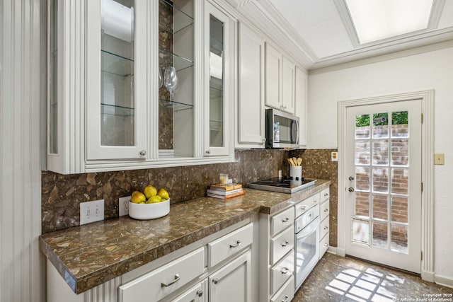 209 Chichester Pl Unit 1, San Antonio, TX 78209 - kitchen featuring black electric cooktop, oven, stainless steel microwave, white cabinets, and decorative backsplash