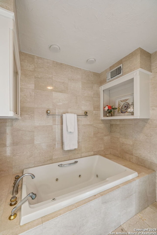209 Chichester Pl Unit 1, San Antonio, TX 78209 - bathroom featuring a jetted tub and tile walls