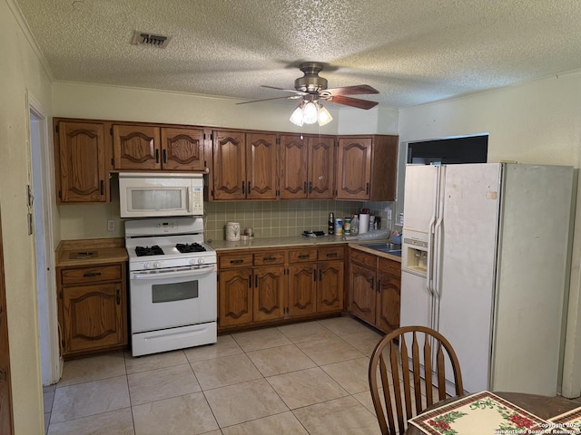 254 W Greenway Ave, San Antonio, TX 78226 - kitchen featuring white appliances, light countertops, a ceiling fan, a textured ceiling, and brown cabinets