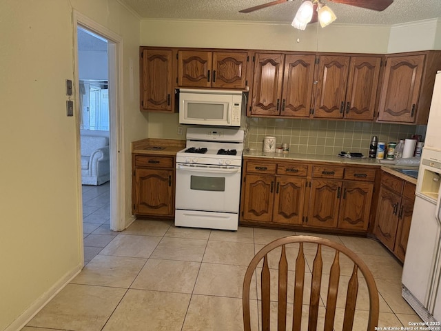 254 W Greenway Ave, San Antonio, TX 78226 - kitchen featuring white appliances, light countertops, a textured ceiling, backsplash, and brown cabinetry
