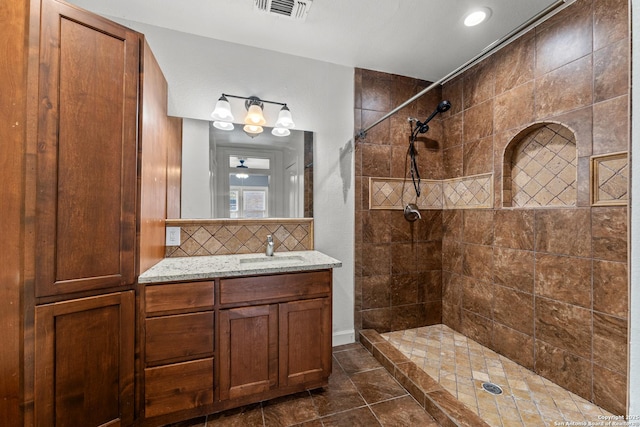 427 Donaldson, San Antonio, TX 78201 - bathroom featuring tiled shower, vanity, tasteful backsplash, a chandelier, and tile patterned floors