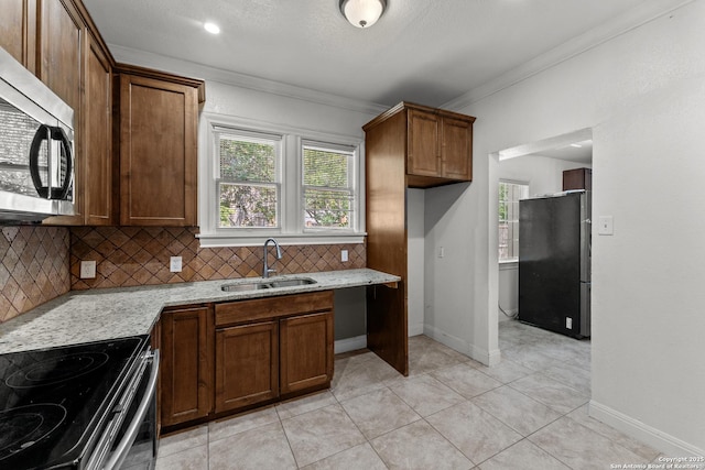427 Donaldson, San Antonio, TX 78201 - kitchen with stainless steel appliances, a sink, ornamental molding, tasteful backsplash, and light stone countertops