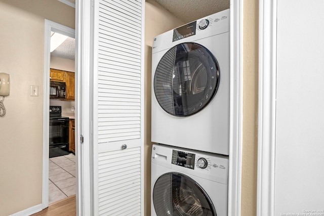 7738 Chambers Unit 612, San Antonio, TX 78229 - laundry area featuring stacked washer / drying machine, a textured ceiling, and light tile patterned floors