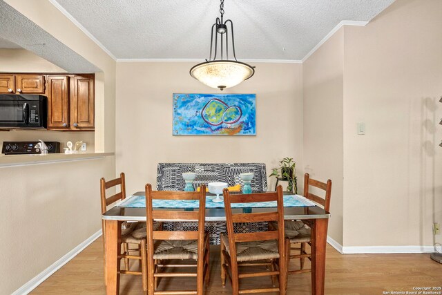 7738 Chambers Unit 612, San Antonio, TX 78229 - dining room featuring light wood-style flooring, a textured ceiling, baseboards, and crown molding