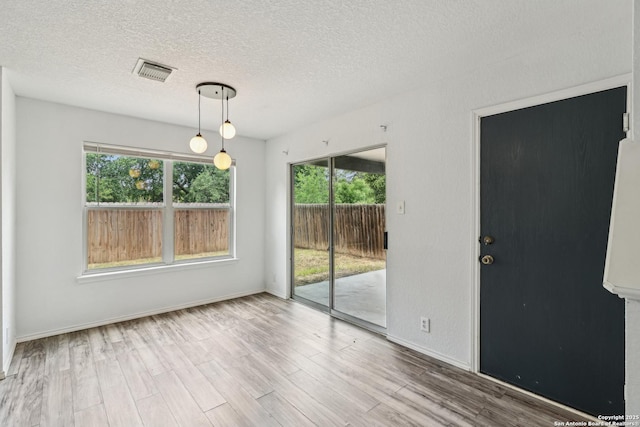 87 Kenrock Rdg, San Antonio, TX 78254 - empty room featuring plenty of natural light, a textured ceiling, wood finished floors, and baseboards