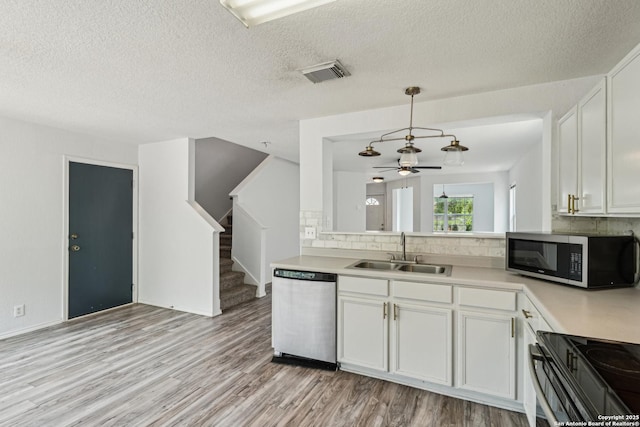 87 Kenrock Rdg, San Antonio, TX 78254 - kitchen with appliances with stainless steel finishes, a sink, backsplash, light wood finished floors, and light countertops