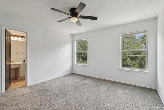 87 Kenrock Rdg, San Antonio, TX 78254 - unfurnished bedroom featuring light carpet, a textured ceiling, connected bathroom, ceiling fan, and baseboards