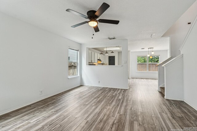 87 Kenrock Rdg, San Antonio, TX 78254 - unfurnished living room featuring wood finished floors, ceiling fan, stairs, and baseboards