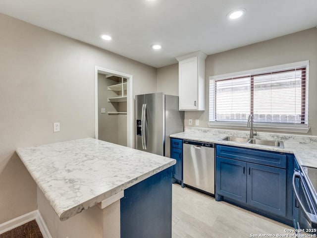 7363 Longing Trl, San Antonio, TX 78244 - kitchen featuring stainless steel appliances, a sink, blue cabinetry, light countertops, and white cabinets