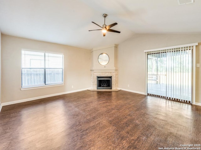 7363 Longing Trl, San Antonio, TX 78244 - unfurnished living room with a ceiling fan, plenty of natural light, dark wood-style flooring, vaulted ceiling, and a fireplace with raised hearth