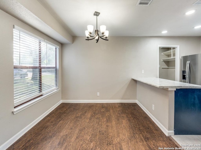 7363 Longing Trl, San Antonio, TX 78244 - unfurnished dining area with wood finished floors, a chandelier, baseboards, recessed lighting, and built in shelves