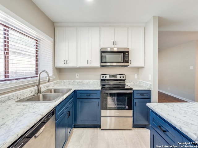 7363 Longing Trl, San Antonio, TX 78244 - kitchen with stainless steel appliances, a sink, white cabinets, and blue cabinetry
