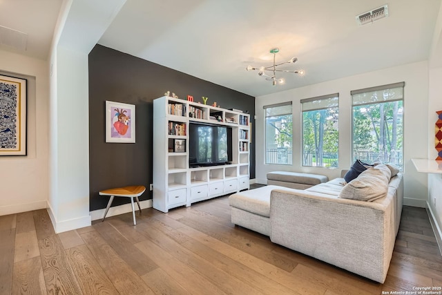 7 Saxby Gln, San Antonio, TX 78257 - living room with a chandelier, baseboards, and hardwood / wood-style floors