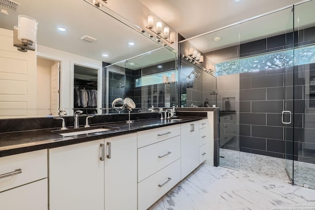 7 Saxby Gln, San Antonio, TX 78257 - bathroom featuring double vanity, a shower stall, a walk in closet, recessed lighting, and marble finish floors