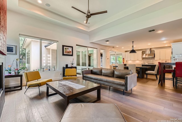 7 Saxby Gln, San Antonio, TX 78257 - living room featuring ceiling fan, light wood finished floors, recessed lighting, and a raised ceiling