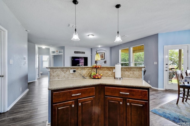 12535 Panola Way, San Antonio, TX 78253 - kitchen featuring backsplash, dark wood-style floors, a textured ceiling, light countertops, and hanging light fixtures
