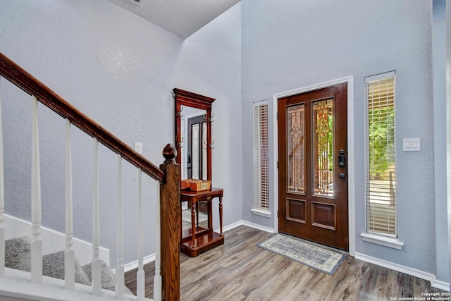 12535 Panola Way, San Antonio, TX 78253 - foyer entrance featuring stairway, wood finished floors, a textured wall, baseboards, and a towering ceiling