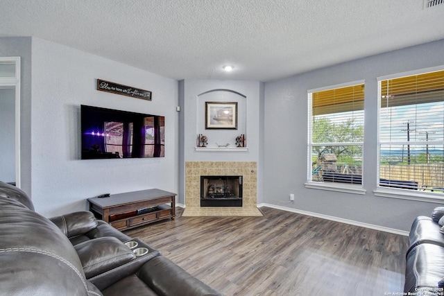 12535 Panola Way, San Antonio, TX 78253 - living room featuring a textured ceiling, wood finished floors, baseboards, and a tile fireplace