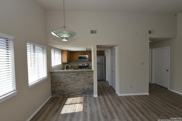 12610 Uhr Ln Unit 281, San Antonio, TX 78217 - kitchen featuring appliances with stainless steel finishes, brown cabinets, a high ceiling, baseboards, and wood finished floors