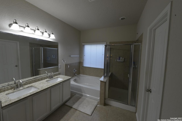 12610 Uhr Ln Unit 281, San Antonio, TX 78217 - full bathroom featuring tile patterned floors, a bath, a shower stall, double vanity, and a textured ceiling