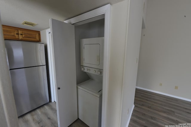 12610 Uhr Ln Unit 281, San Antonio, TX 78217 - laundry room featuring stacked washer and clothes dryer, wood finished floors, and baseboards