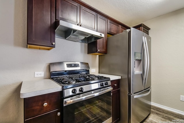 202 Reuben Kemper, San Antonio, TX 78220 - kitchen with stainless steel appliances, under cabinet range hood, wood finished floors, baseboards, and light countertops