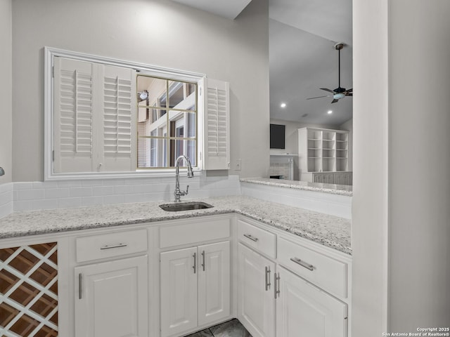 16 Cheshire, San Antonio, TX 78218 - kitchen with a sink, ceiling fan, white cabinets, and light stone countertops