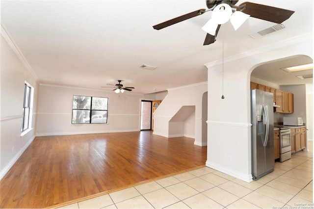 10322 Fork Crk, San Antonio, TX 78245 - unfurnished living room featuring ceiling fan, arched walkways, ornamental molding, light wood-type flooring, and baseboards