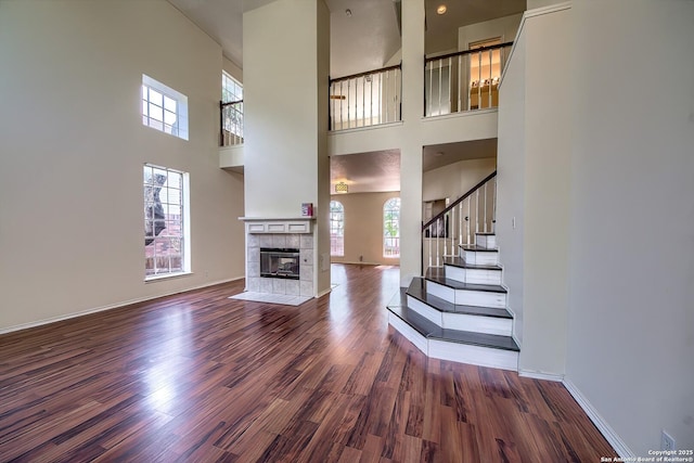 1510 Kingsbridge, San Antonio, TX 78253 - unfurnished living room featuring wood finished floors, a towering ceiling, stairway, a fireplace, and baseboards