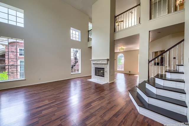 1510 Kingsbridge, San Antonio, TX 78253 - unfurnished living room with a high ceiling, dark wood-style flooring, stairway, a tile fireplace, and baseboards