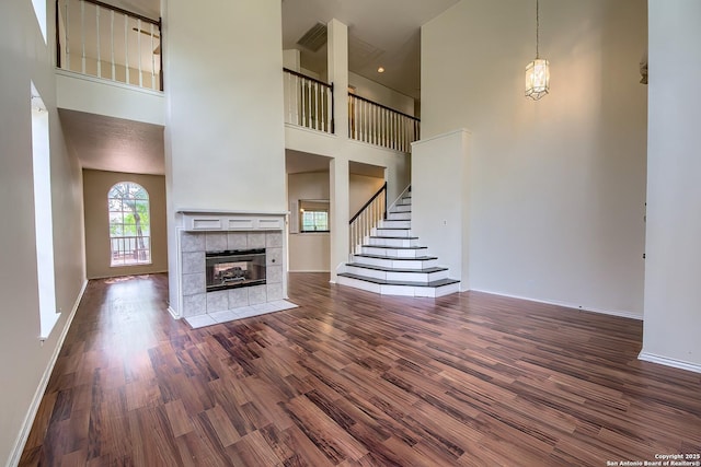 1510 Kingsbridge, San Antonio, TX 78253 - unfurnished living room with a towering ceiling, wood finished floors, a tile fireplace, baseboards, and stairway