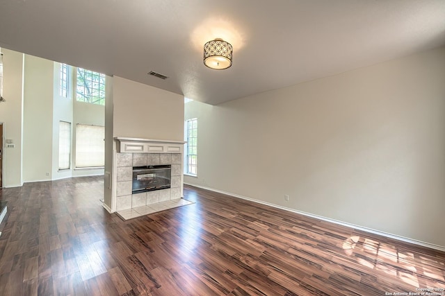 1510 Kingsbridge, San Antonio, TX 78253 - unfurnished living room with healthy amount of natural light, dark wood-style floors, a tiled fireplace, and baseboards