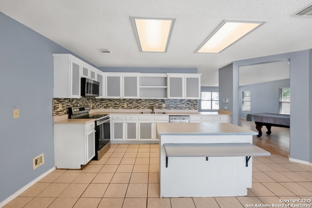 9503 Marshall Pt, San Antonio, TX 78240 - kitchen with appliances with stainless steel finishes, open shelves, decorative backsplash, light countertops, and a textured ceiling