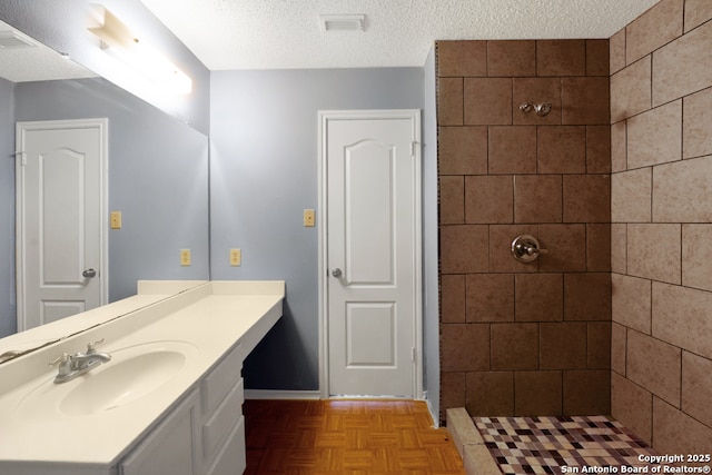 9503 Marshall Pt, San Antonio, TX 78240 - full bathroom with tiled shower, vanity, and a textured ceiling