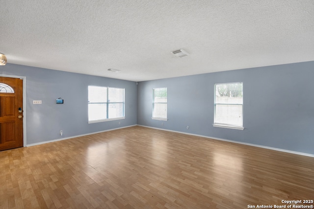 9503 Marshall Pt, San Antonio, TX 78240 - spare room featuring light wood-style flooring, a textured ceiling, and baseboards
