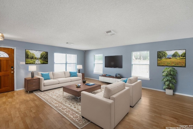9503 Marshall Pt, San Antonio, TX 78240 - living area featuring light wood finished floors, a textured ceiling, and baseboards