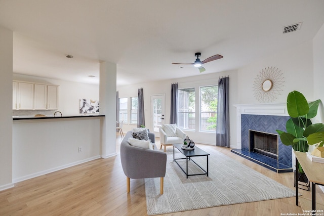 12031 Wellstone, San Antonio, TX 78249 - living area with light wood-style floors, a fireplace, baseboards, and ceiling fan