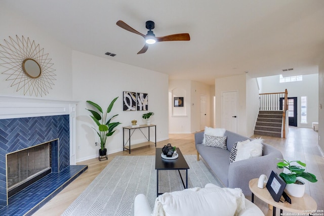 12031 Wellstone, San Antonio, TX 78249 - living room featuring light wood-style flooring, stairway, a ceiling fan, a fireplace, and baseboards