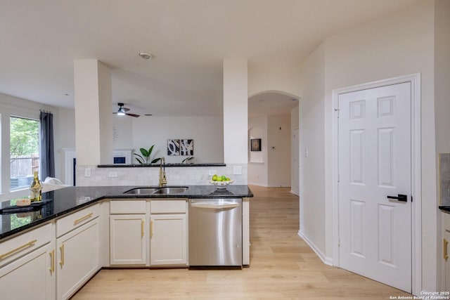 12031 Wellstone, San Antonio, TX 78249 - kitchen featuring stainless steel dishwasher, a sink, ceiling fan, arched walkways, and dark stone countertops
