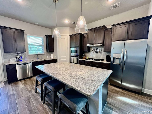 251 Burning Star Blvd, Castroville, TX 78009 - kitchen featuring appliances with stainless steel finishes, a center island, dark wood-style floors, dark brown cabinets, and recessed lighting