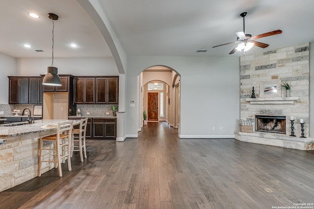 2714 Trailmont Dr, San Antonio, TX 78253 - kitchen with a ceiling fan, open floor plan, a sink, arched walkways, and dark brown cabinets