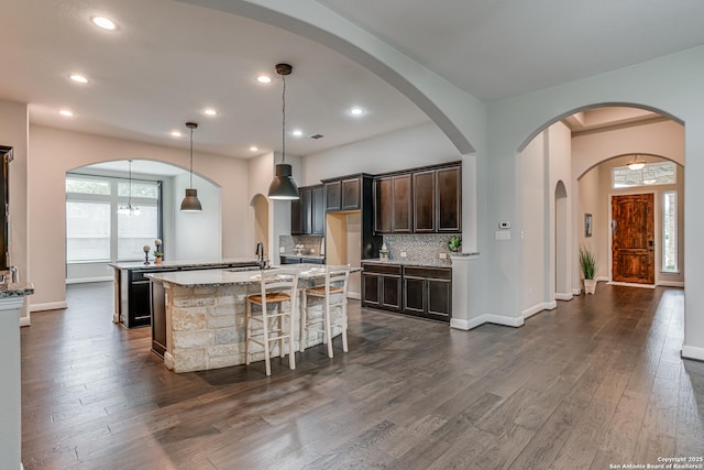 2714 Trailmont Dr, San Antonio, TX 78253 - kitchen with an island with sink, a sink, dark wood finished floors, dark brown cabinetry, and recessed lighting