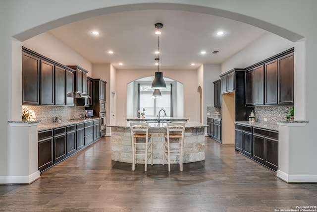 2714 Trailmont Dr, San Antonio, TX 78253 - kitchen featuring a kitchen island with sink, dark brown cabinetry, decorative backsplash, and recessed lighting