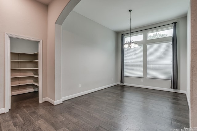 2714 Trailmont Dr, San Antonio, TX 78253 - unfurnished dining area with arched walkways, a chandelier, dark wood-type flooring, and baseboards