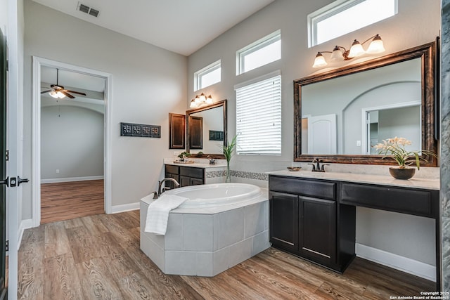 2714 Trailmont Dr, San Antonio, TX 78253 - bathroom with a garden tub, two vanities, a ceiling fan, and wood finished floors